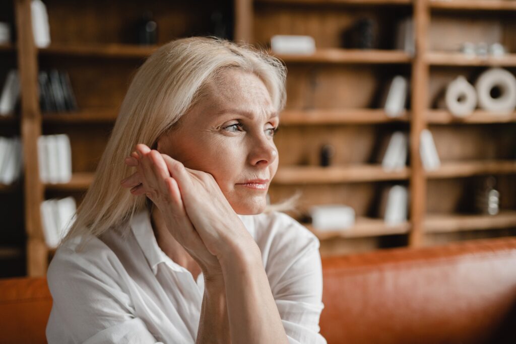 Psychologist appointment. Stressed sad tired exhausted caucasian middle-aged mature businesswoman freelancer relaxing on the couch sofa, thinking about family marriage work problems at work office migraine à la ménopause